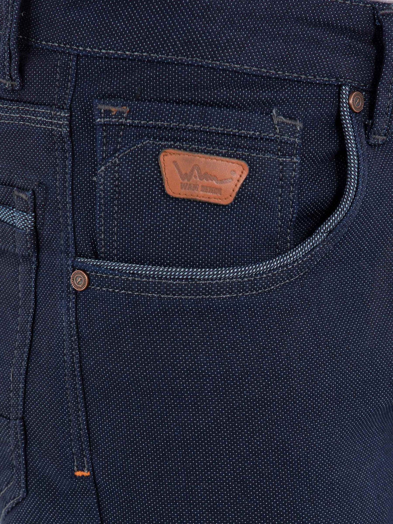 Close-up of dark blue jeans pocket with leather Wam Denim logo patch – Wam Denim.