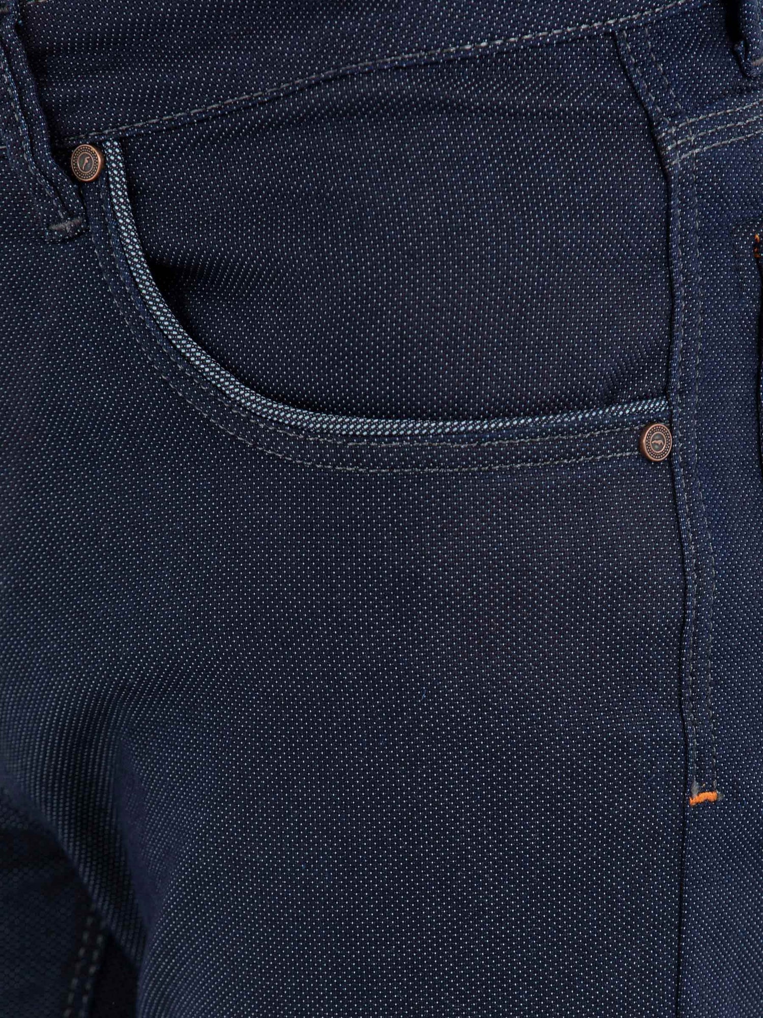 Close-up of front pocket and stitching on dark blue slim-fit jeans – Wam Denim.