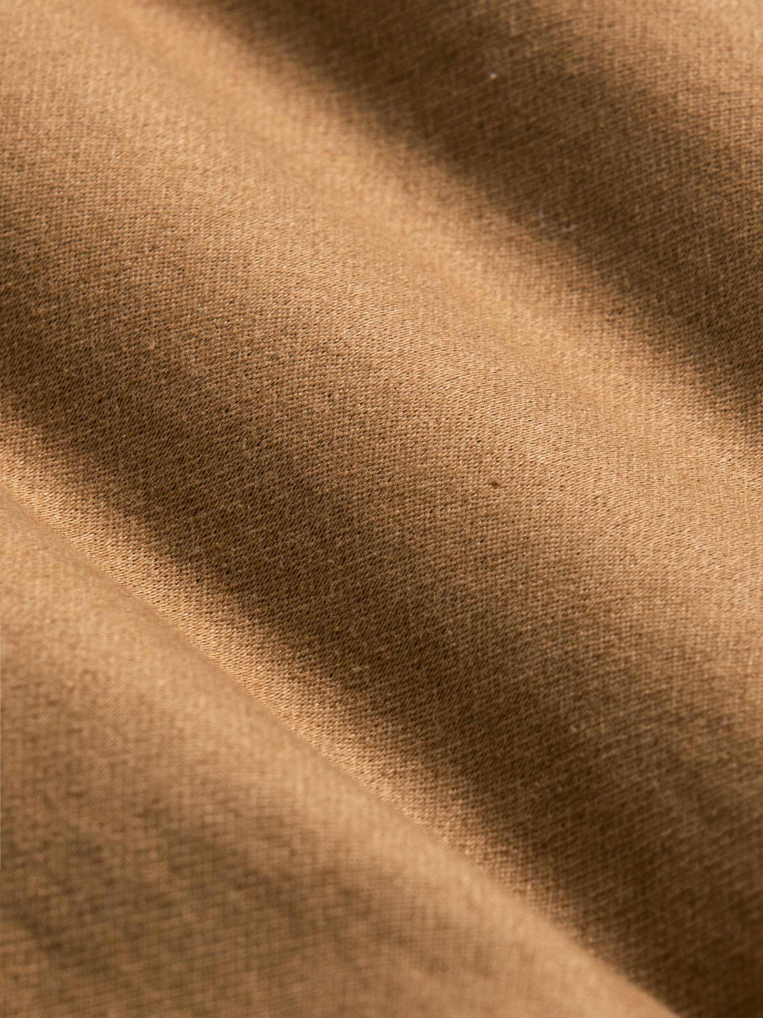 Close-up of soft camel brown fabric showing smooth texture and fine weave – Wam Denim.