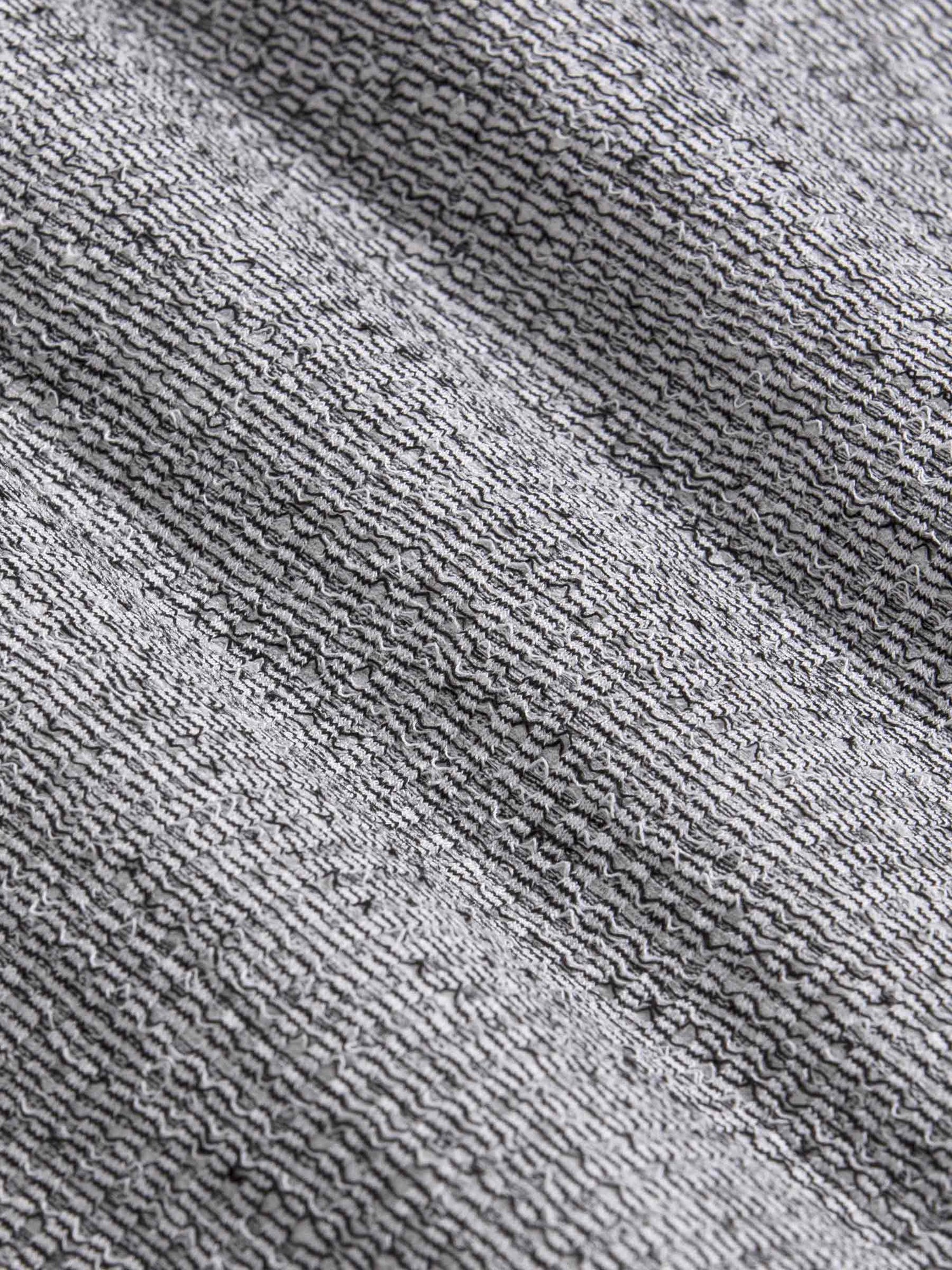 Close-up texture of grey marl knit fabric with black stripes – Wam Denim.