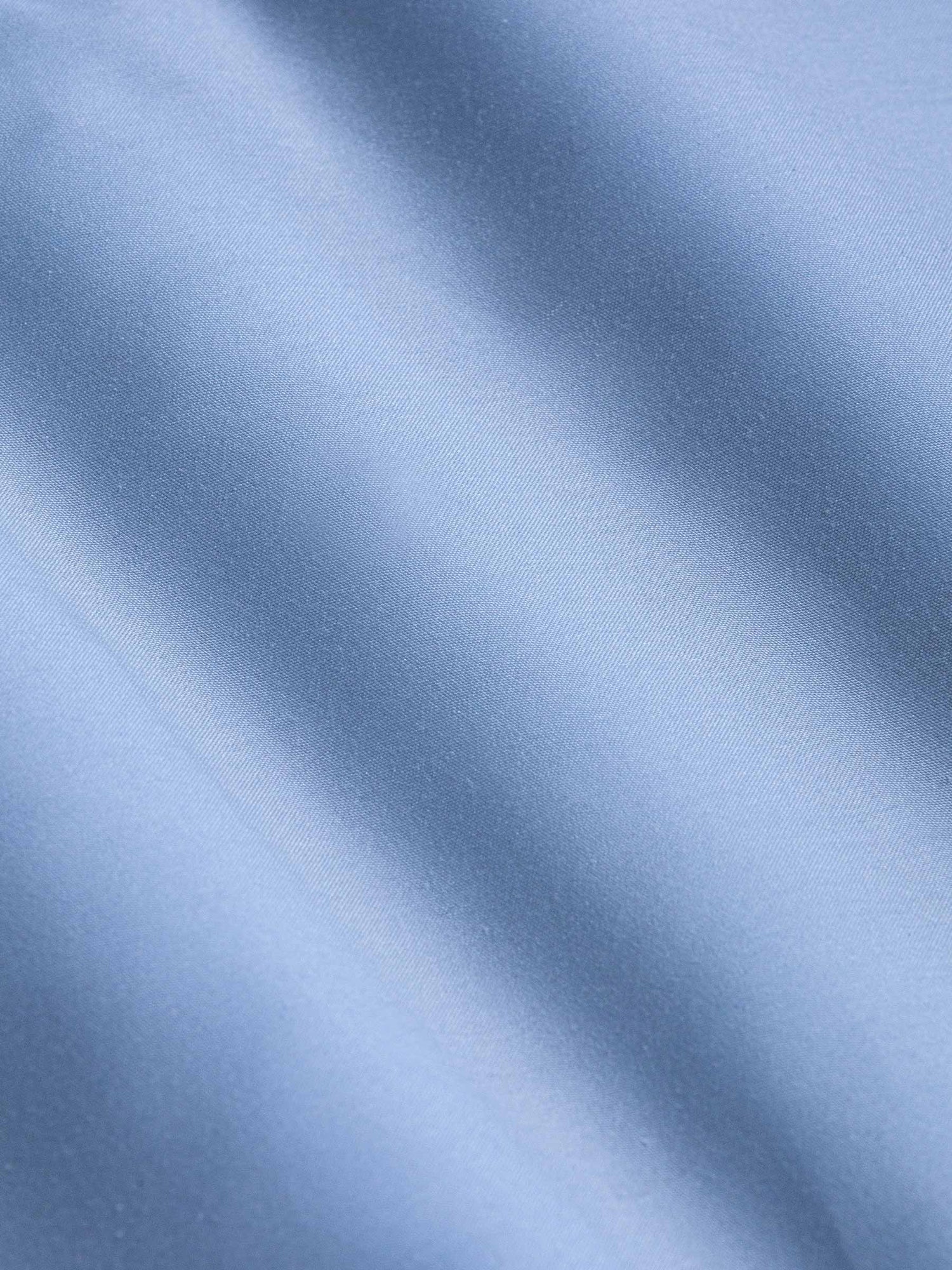 Close-up of smooth light blue fabric showing soft texture and fine weave – Wam Denim.