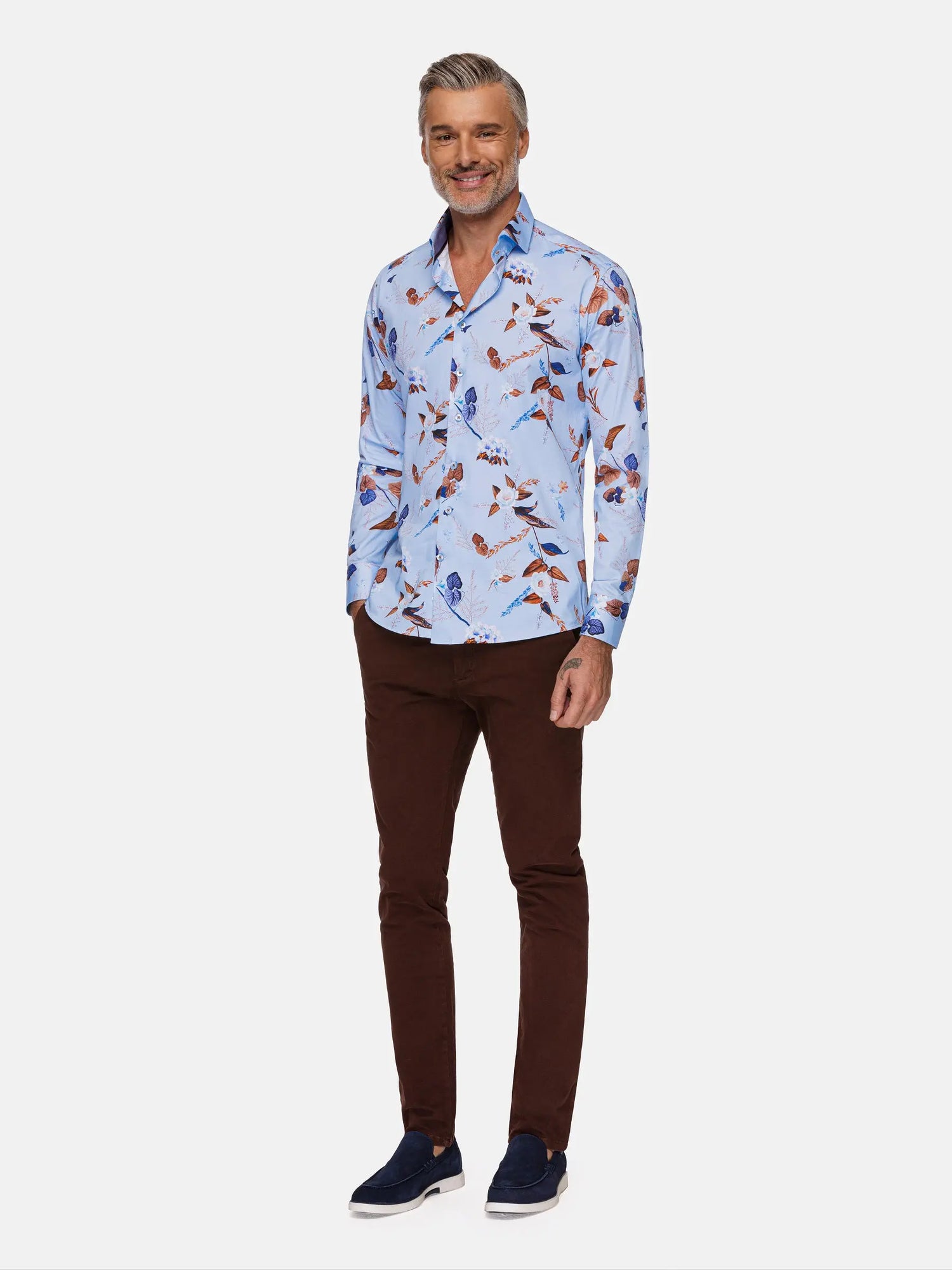 Man wearing light blue floral dress shirt paired with brown pants and navy loafers – Wam Denim.