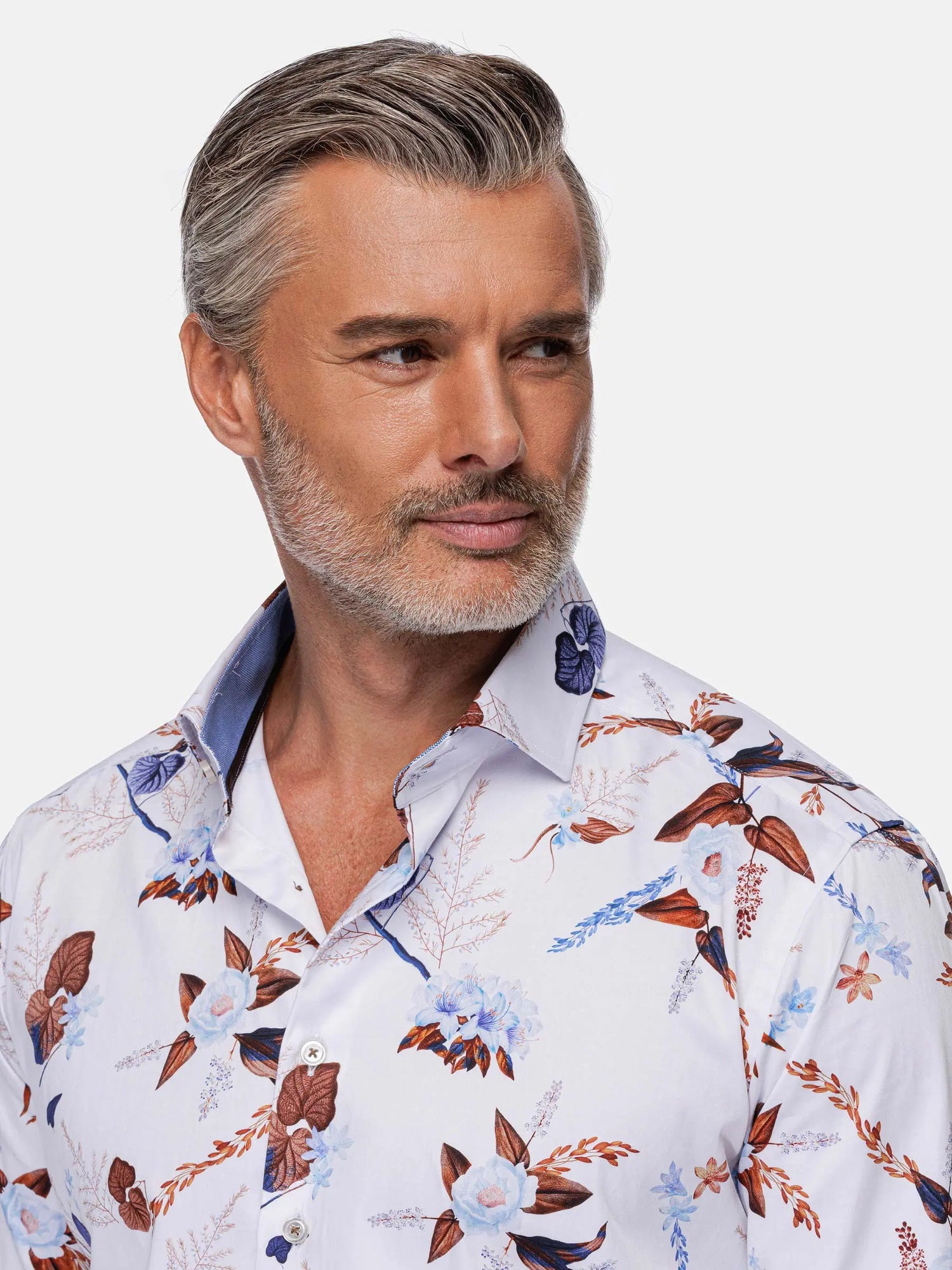 Close-up of man wearing white floral shirt with blue and brown print details – Wam Denim.