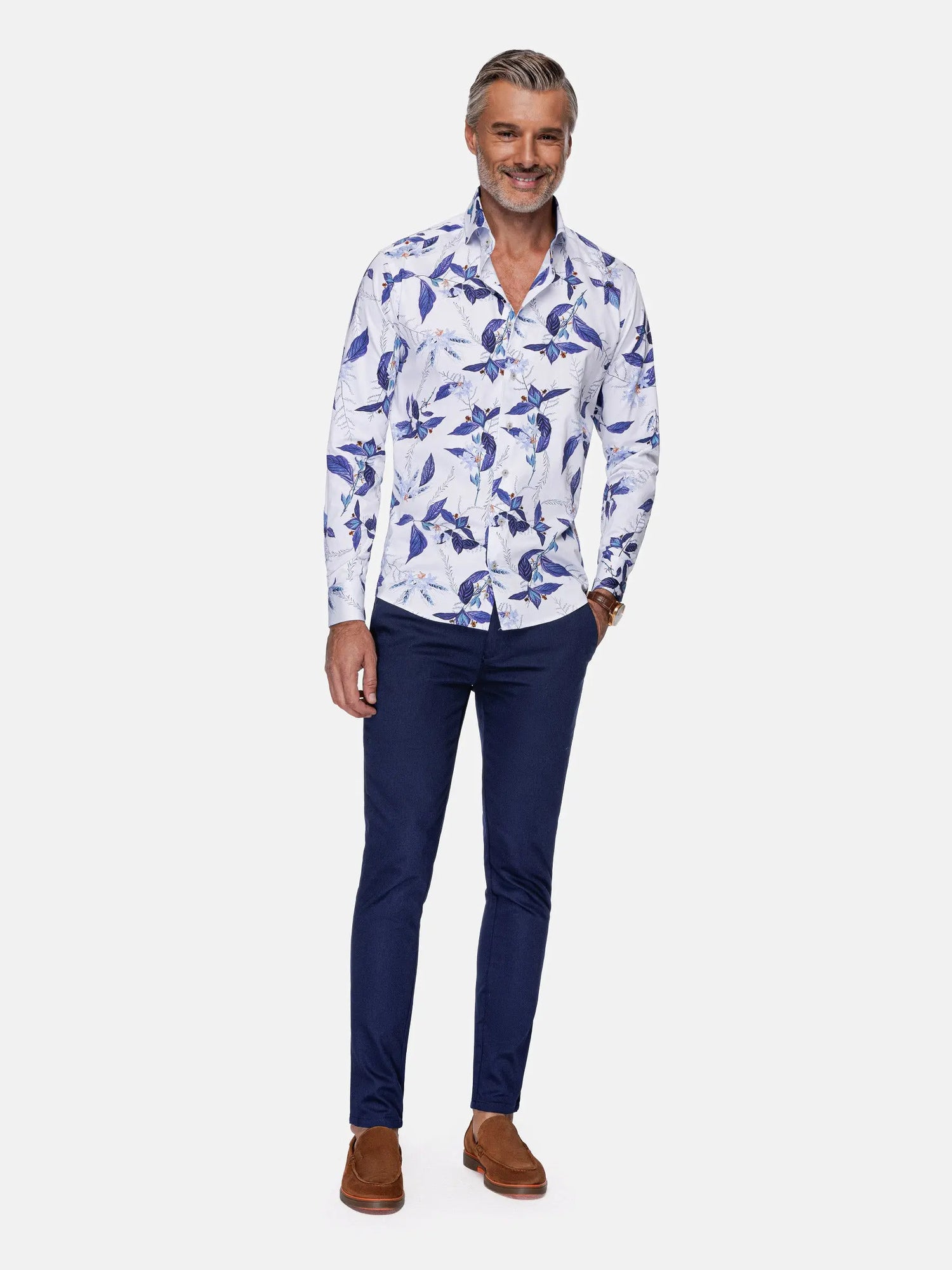 Man wearing white and blue floral print shirt paired with navy trousers and brown loafers – Wam Denim.