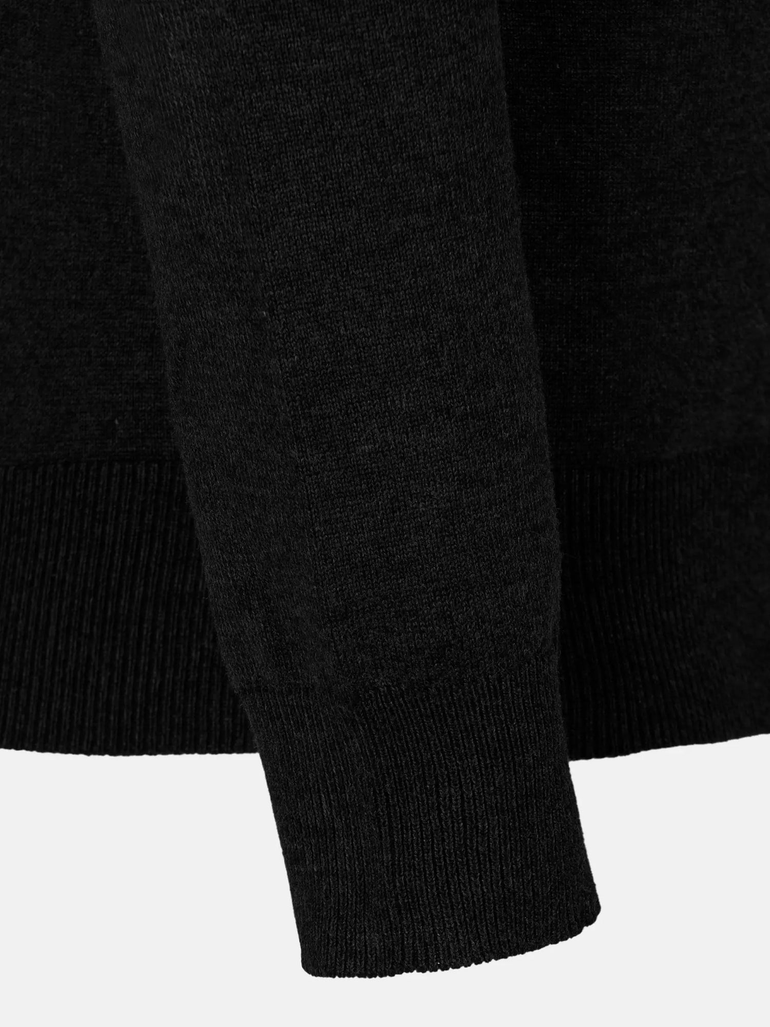 Close-up of the ribbed cuff on a black V-neck sweater – Wam Denim.