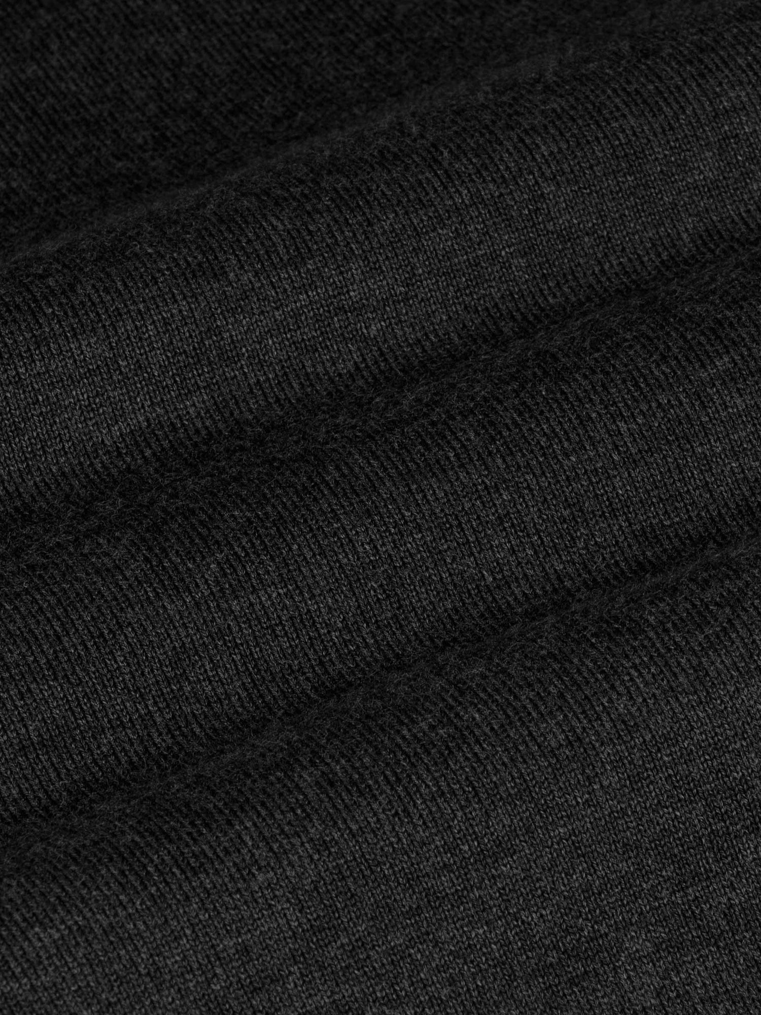 Close-up of the black knit fabric on the V-neck sweater – Wam Denim.
