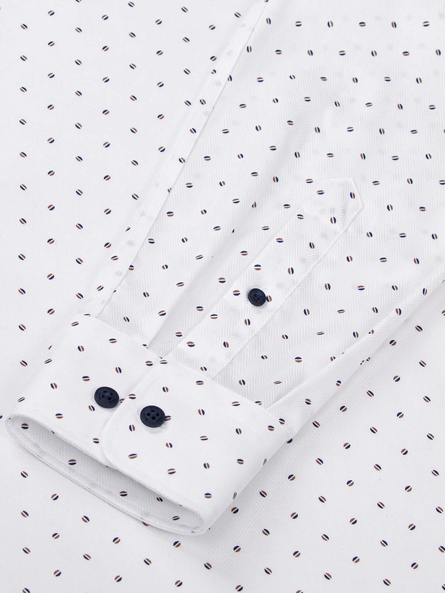 Close-up of white shirt sleeve with navy buttons and dotted pattern detailing – Wam Denim.