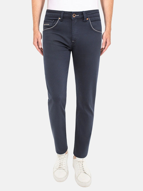 Man wearing dark blue slim-fit jeans with white sneakers. – Wam Denim.