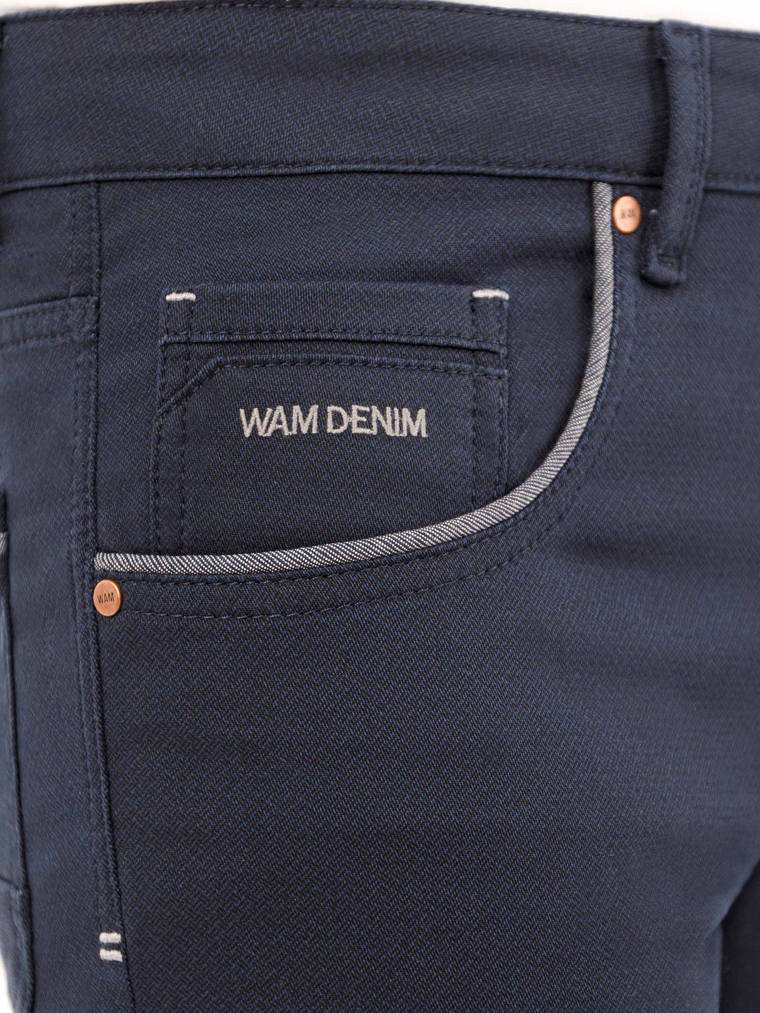 Close-up of dark blue jeans with branded pocket and stitching. – Wam Denim.