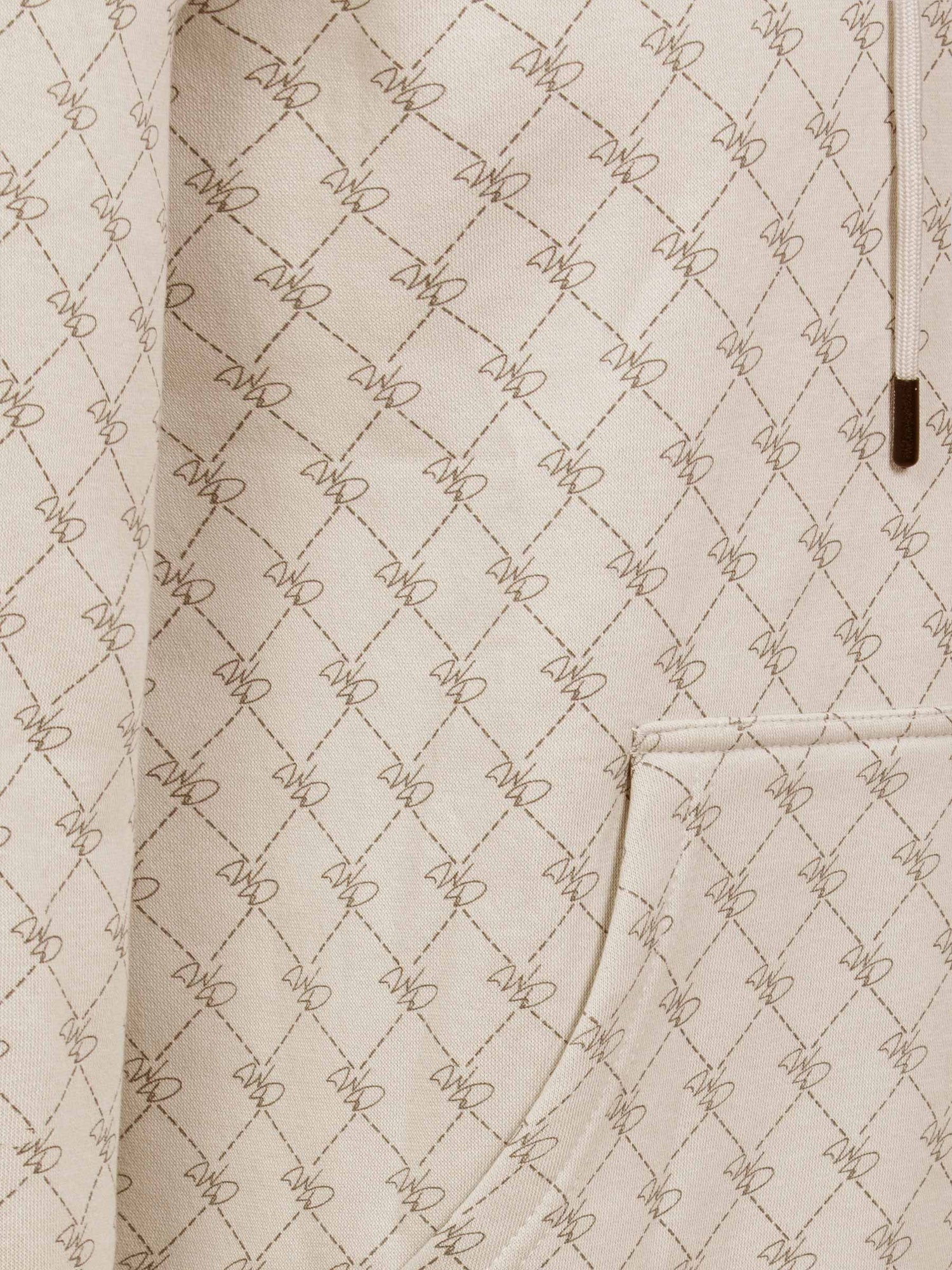Close-up of beige hoodie pocket with stitched geometric pattern and fine detailing – Wam Denim.