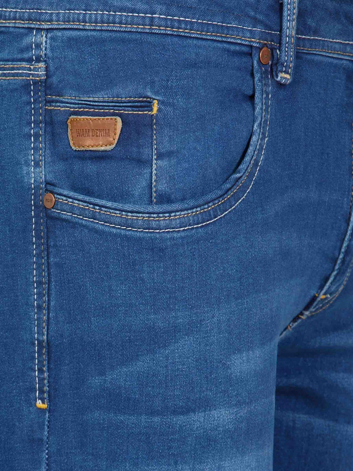 Front pocket close-up of light blue jeans with leather Wam Denim tag and contrast stitching – Wam Denim.