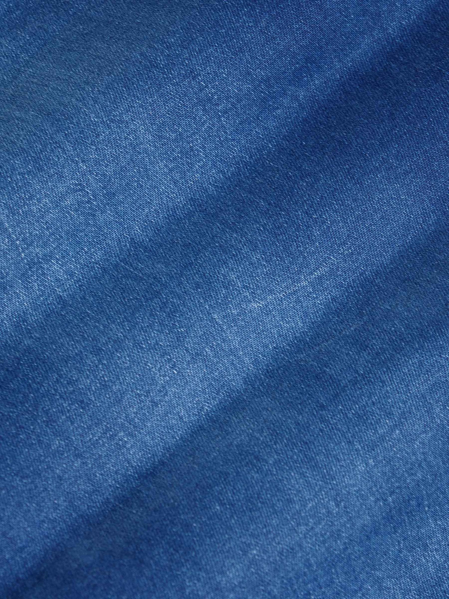 Close-up texture of light blue denim fabric showing fine weave and smooth finish – Wam Denim.