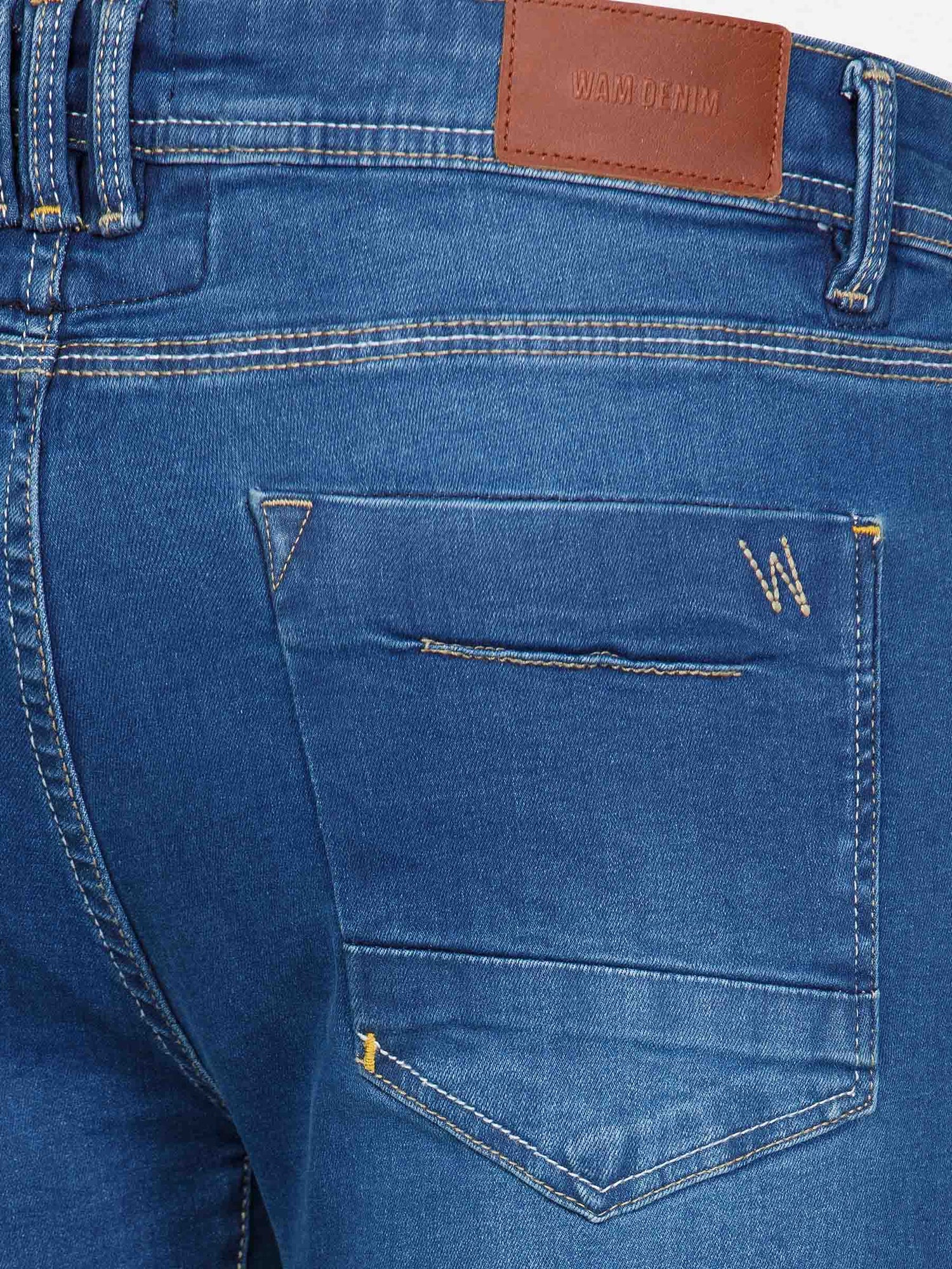 Back pocket close-up of light blue jeans with leather Wam Denim label and stitched “W” – Wam Denim.
