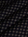 Close-up of black fabric with beige geometric pattern showing soft textured weave – Wam Denim.