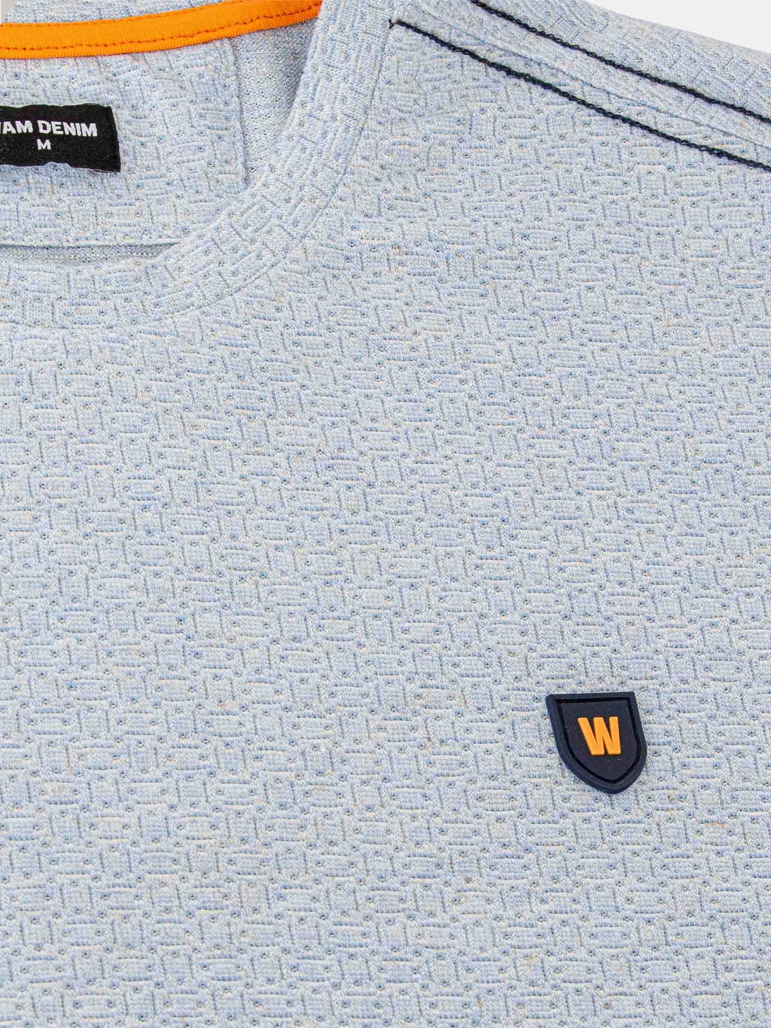 Close-up of the textured fabric on the blue t-shirt – Wam Denim.