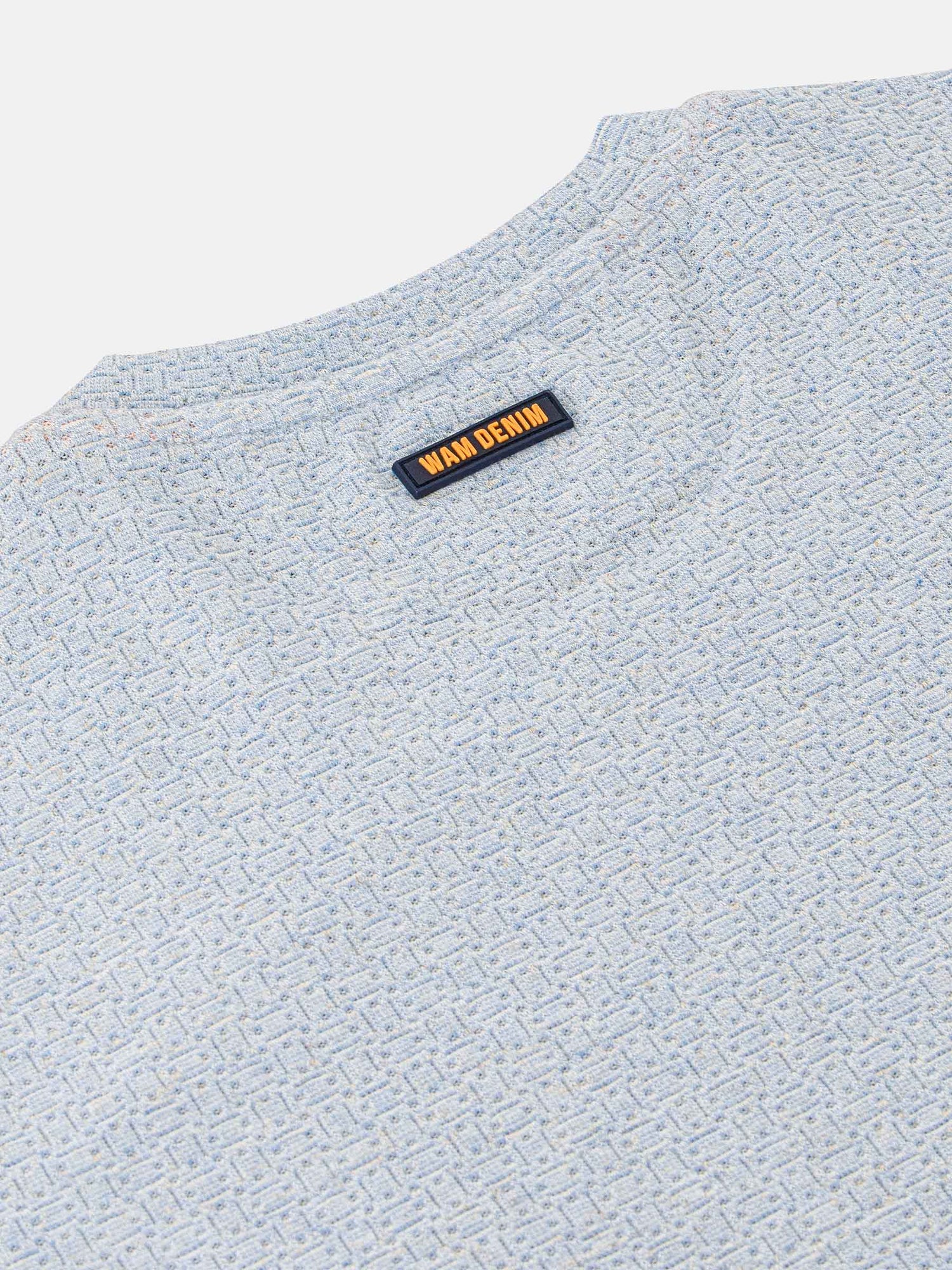 Close-up of the Wam Denim neck label on a blue marl t-shirt – Wam Denim.