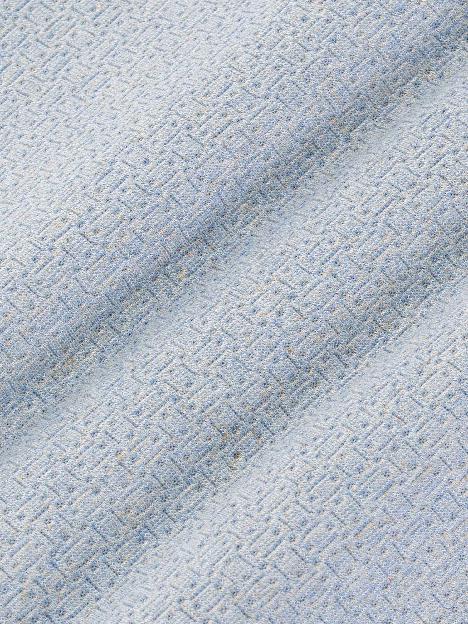 Close-up texture of blue fabric with a geometric pattern – Wam Denim.