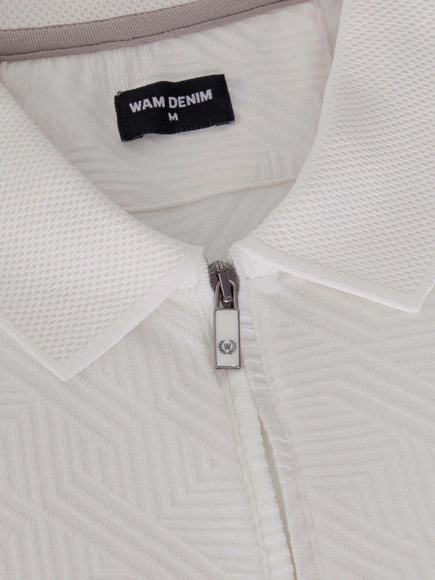 Close-up of the zipper and collar on the white zip polo shirt – Wam Denim.