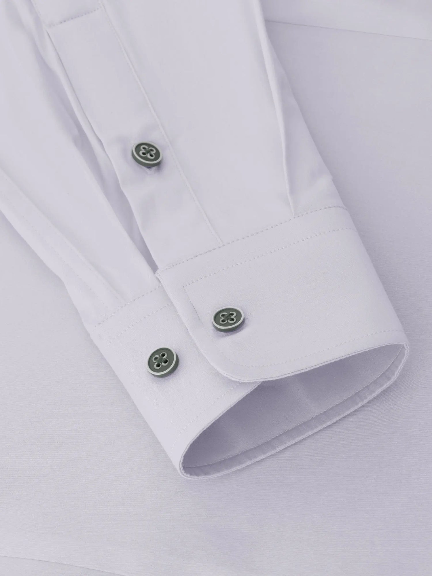 Close-up of the cuff on a white men's dress shirt with green buttons – Wam Denim.