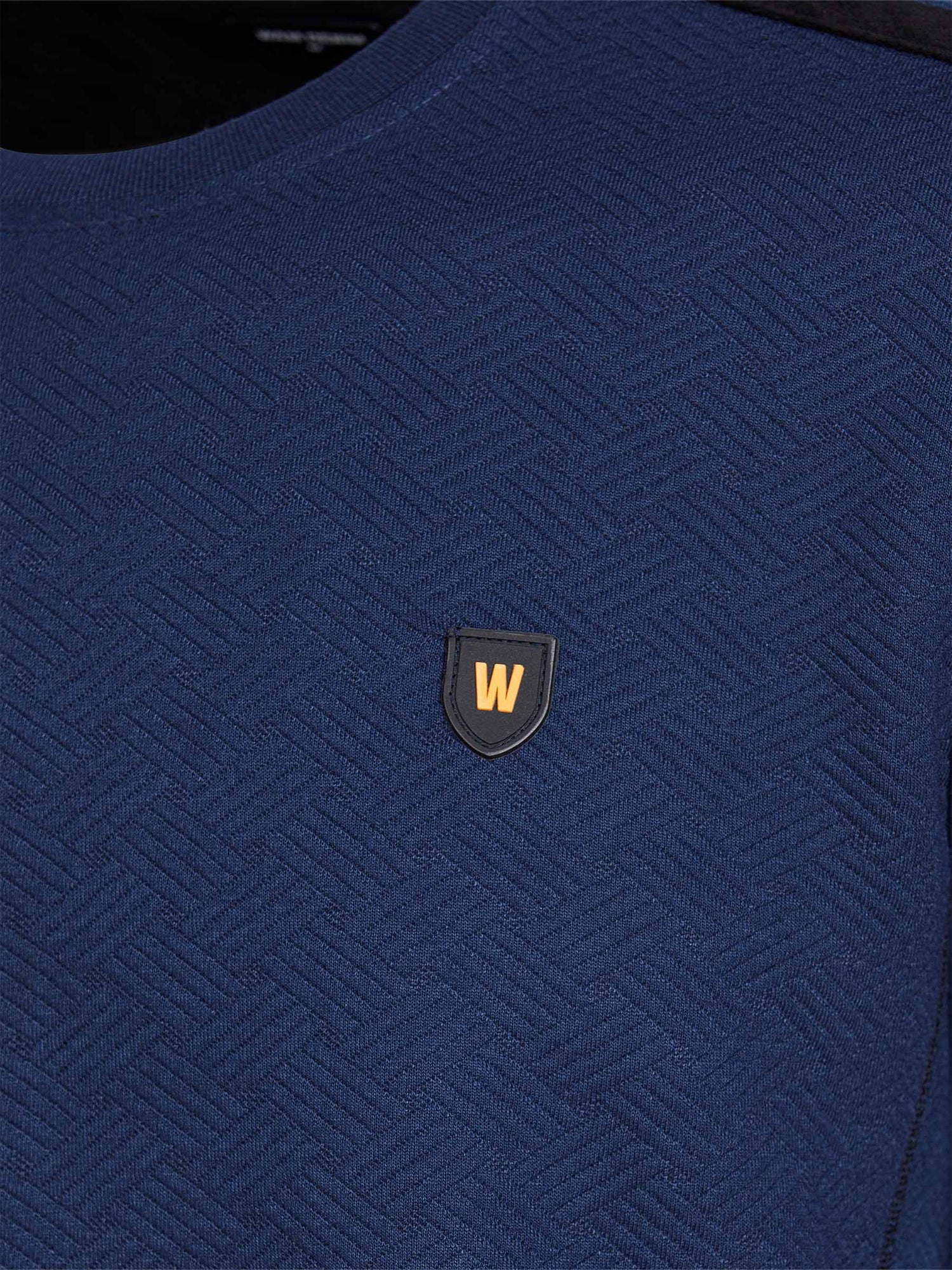 Close-up of navy Moorland Sweater with logo detail. – Wam Denim.