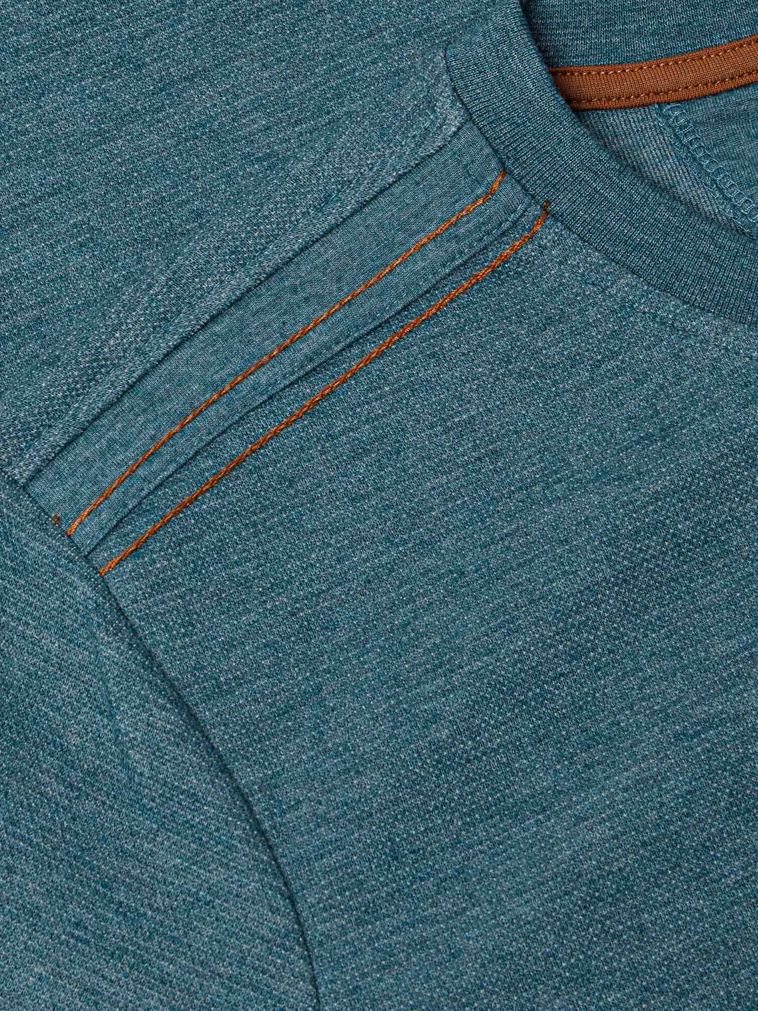 Close-up of shoulder stitching detail with contrast orange seams on petrol knit fabric – Wam Denim.