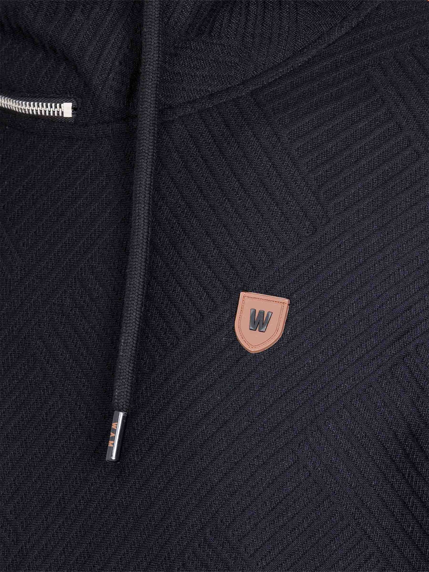 Close-up of chest logo and drawstring detail on black textured sweater – Wam Denim.
