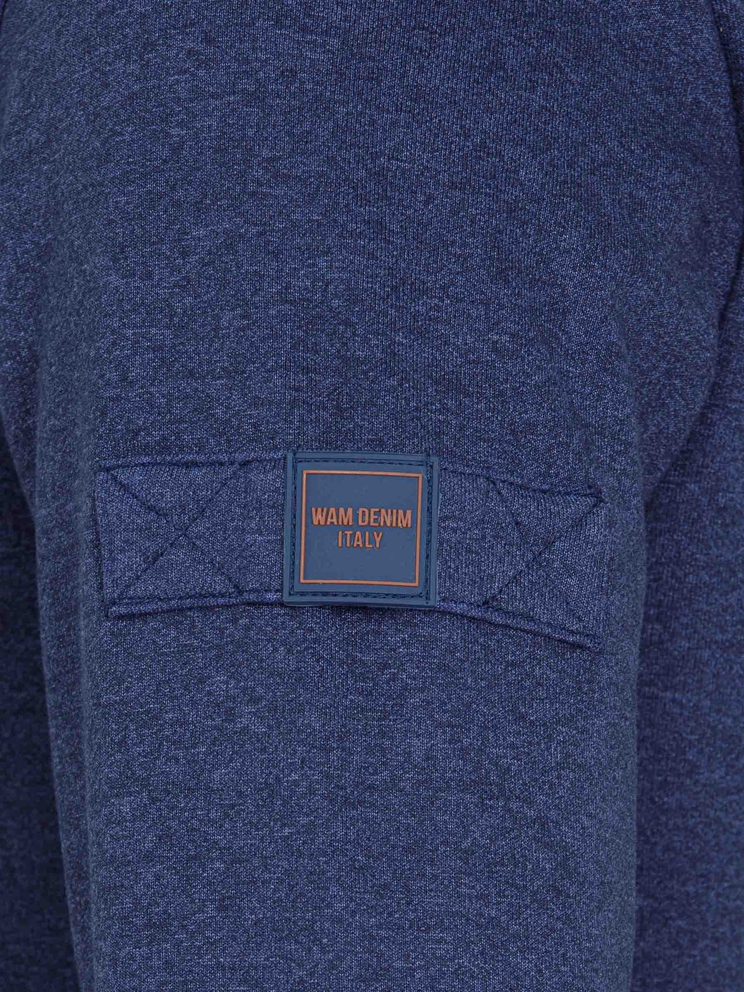Close-up of Wam Denim Italy logo patch on sleeve of light indigo sweater – Wam Denim.