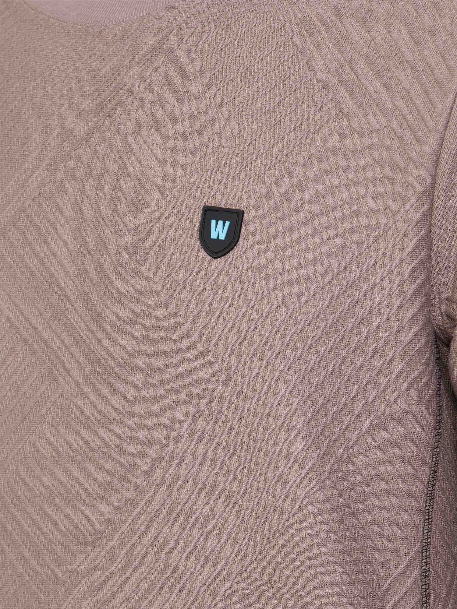 Close-up of the W-shield logo on the textured sweater – Wam Denim.