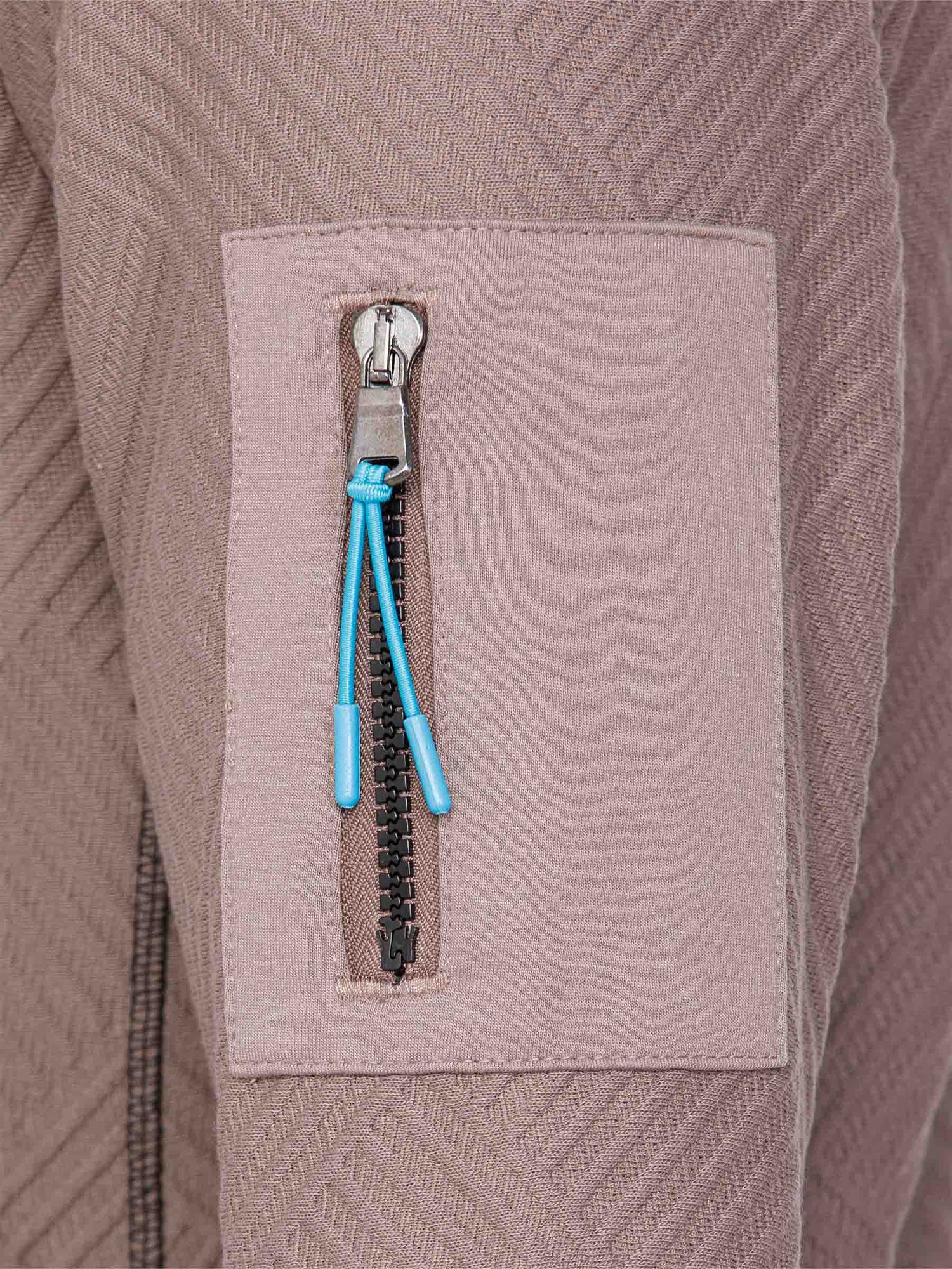 Close-up of the blue zip sleeve pocket on the sweater – Wam Denim.