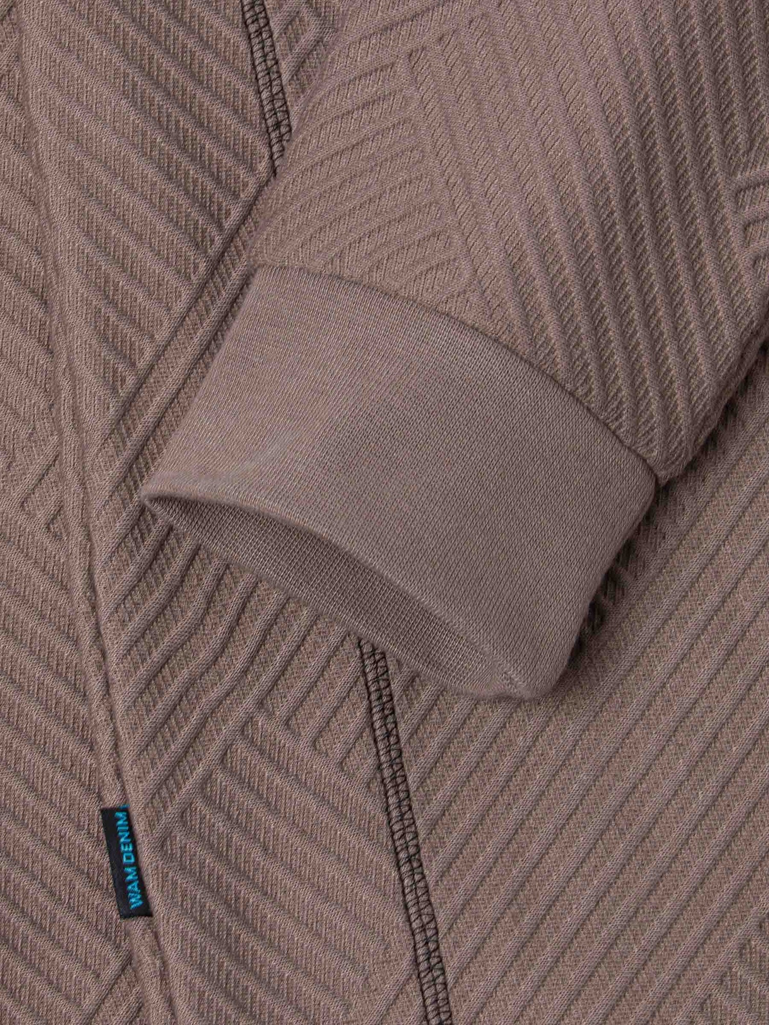 Close-up of the ribbed cuff and knit fabric on the sweater – Wam Denim.