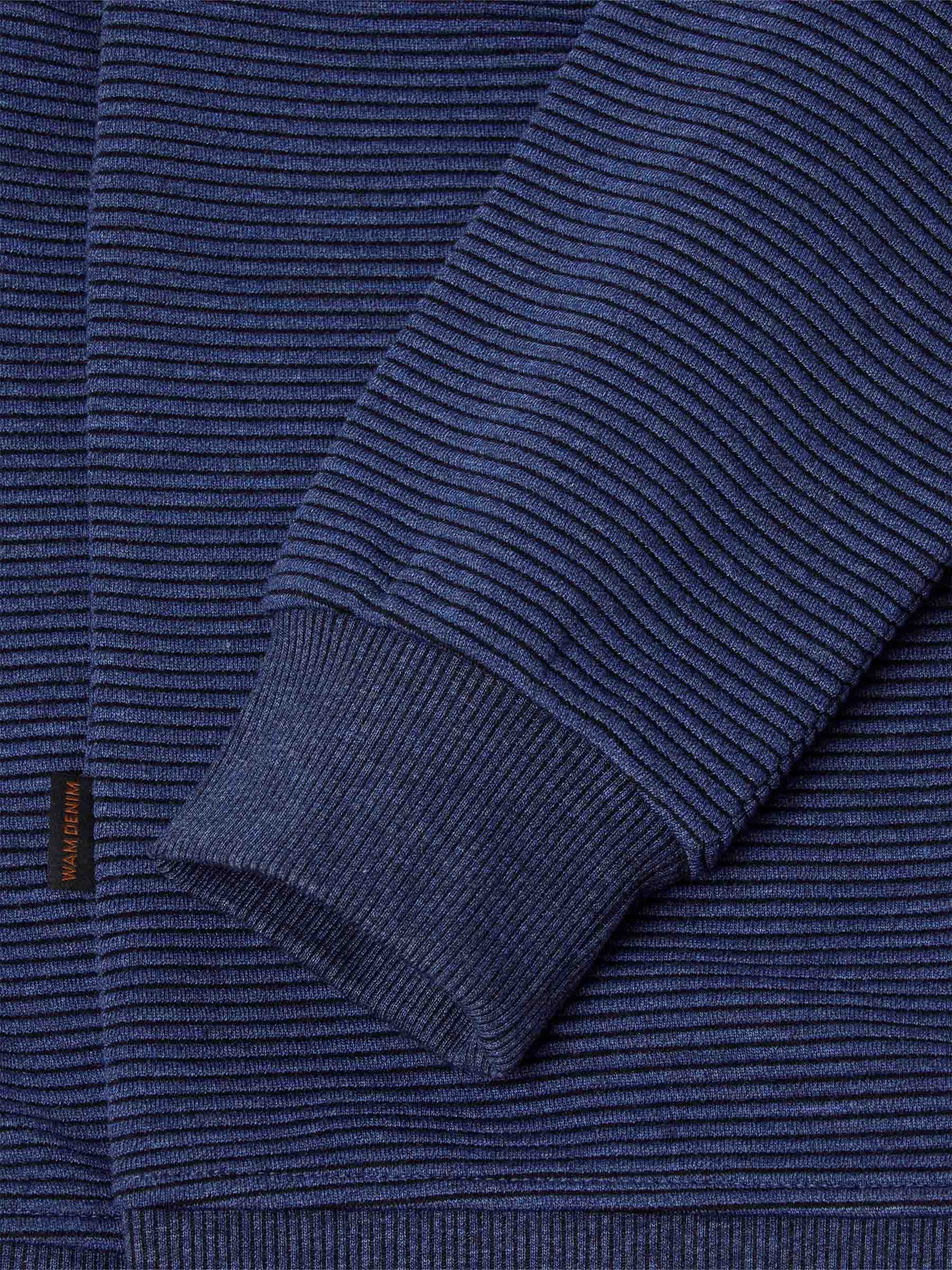 Close-up of the ribbed cuff and stripe knit sleeve on the blue sweater – Wam Denim.