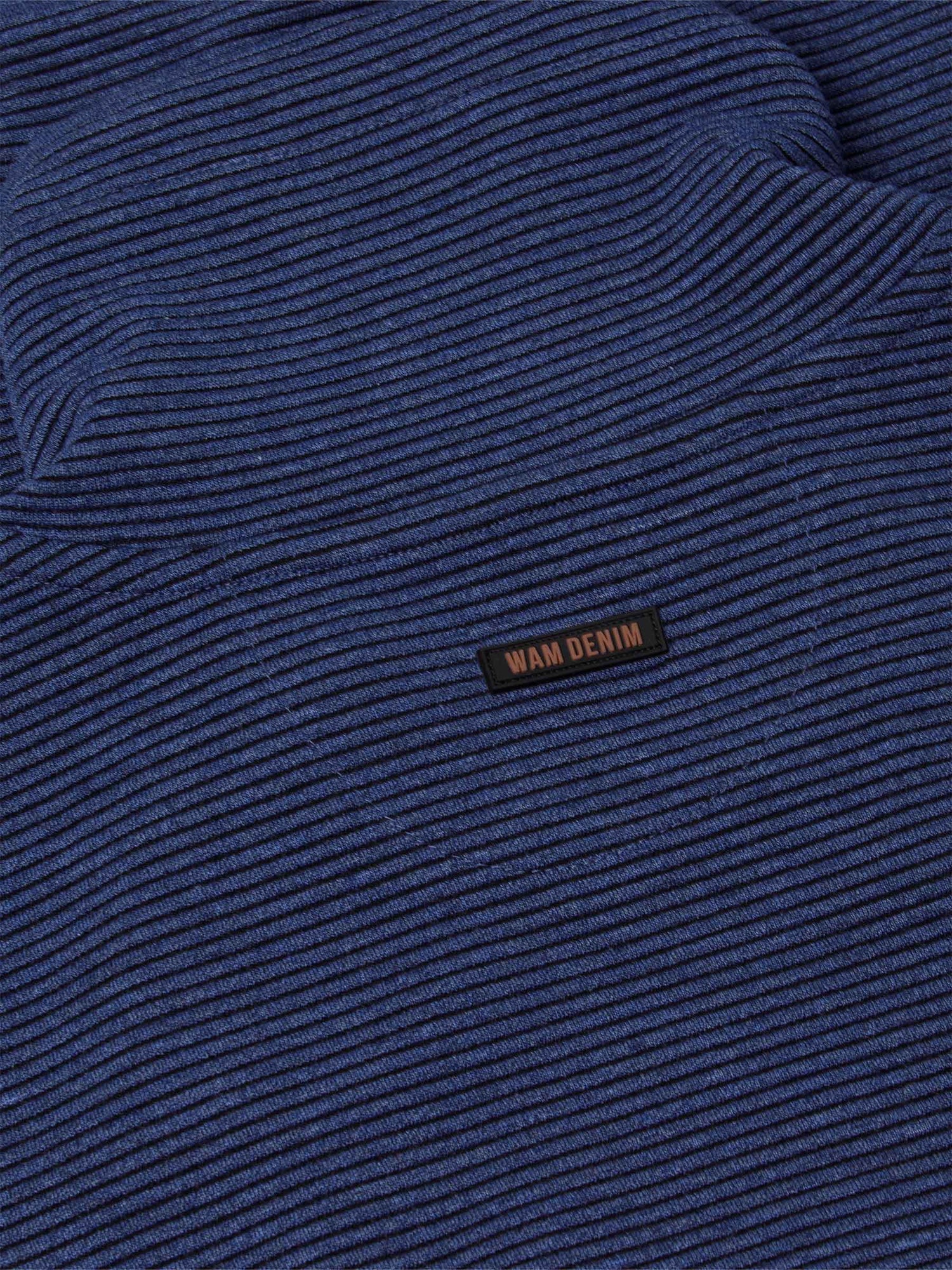 Close-up of the navy knit fabric and Wam Denim label – Wam Denim.
