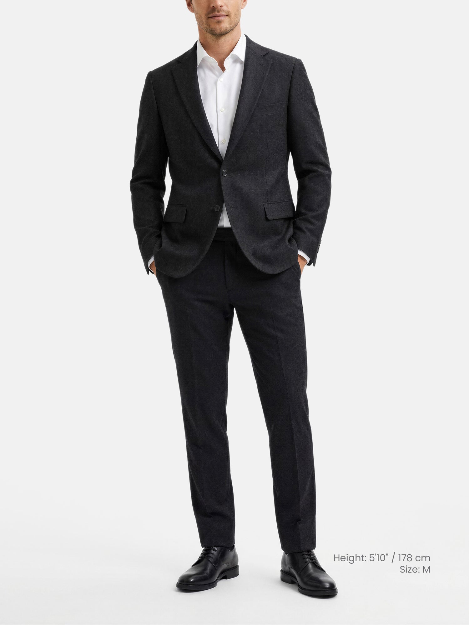 Male model wearing slim fit black blazer with matching trousers and white shirt.