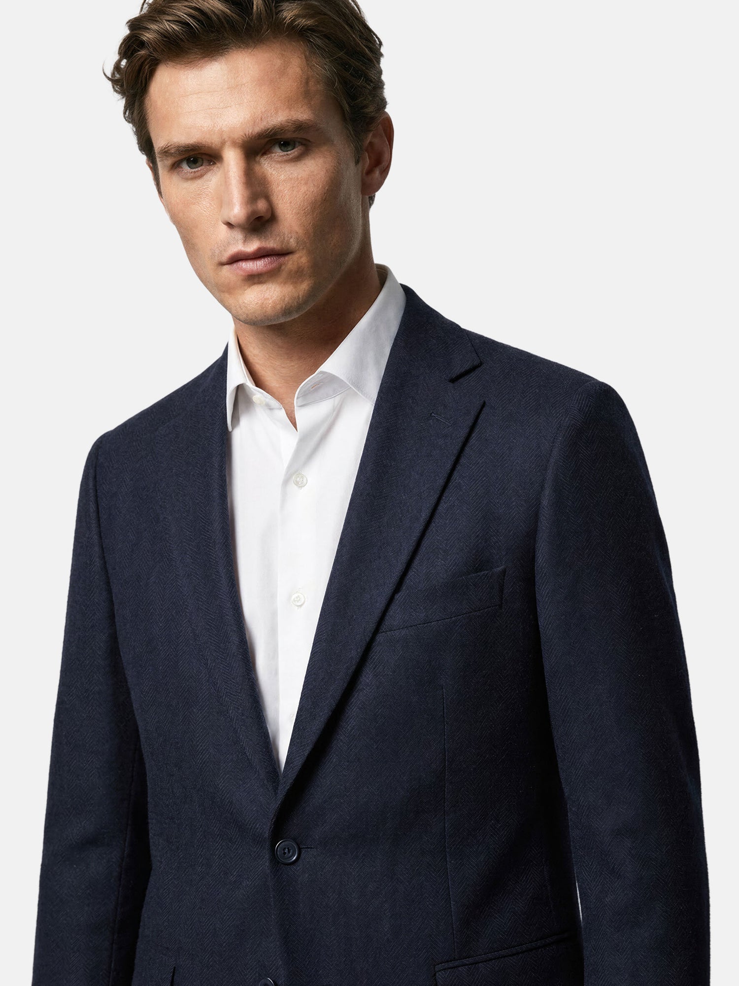 Close-up of slim fit navy men’s blazer with notched lapel detail.