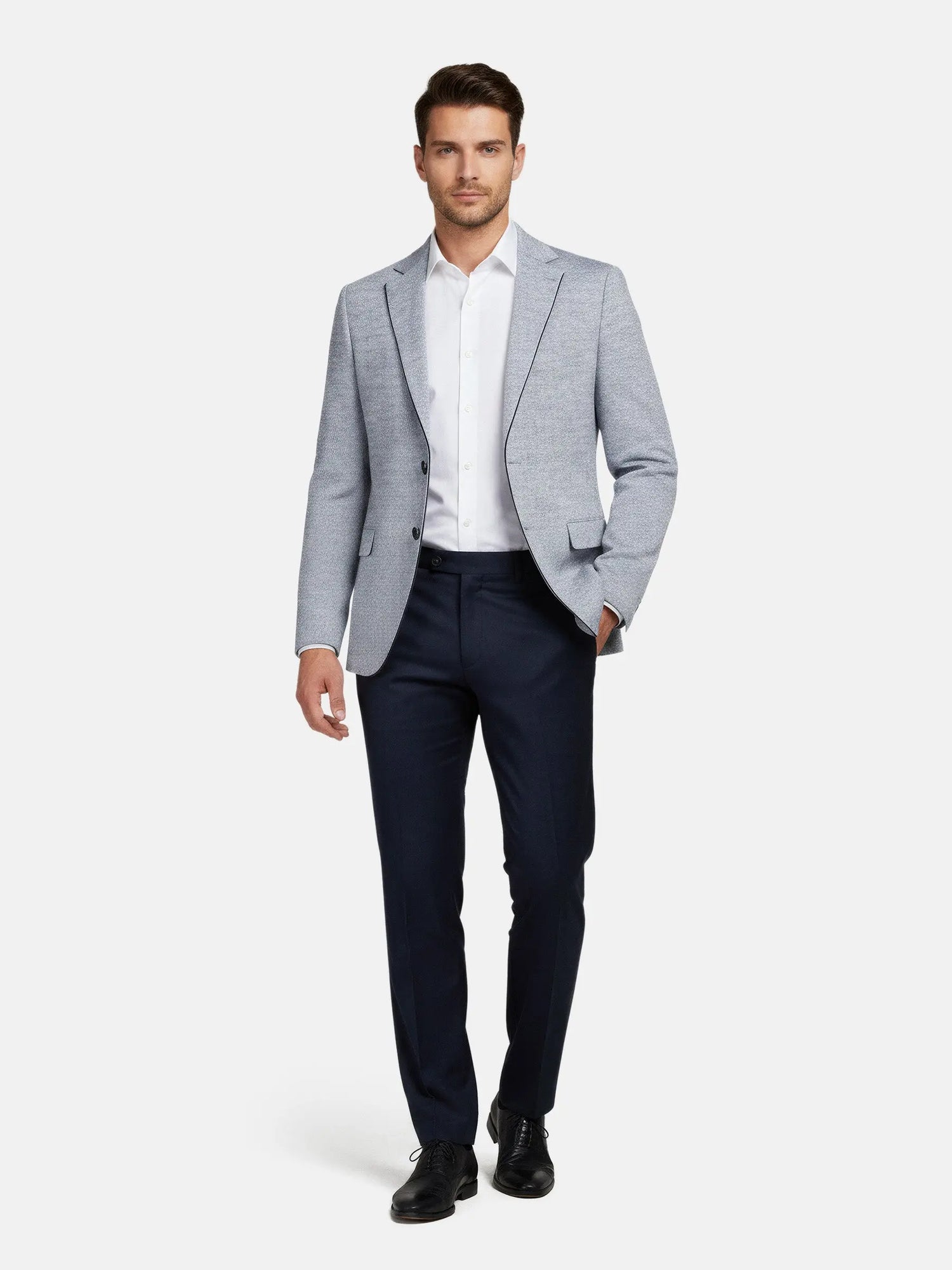 Full-body view of man wearing the white-navy blazer styled with a white shirt and navy trousers.