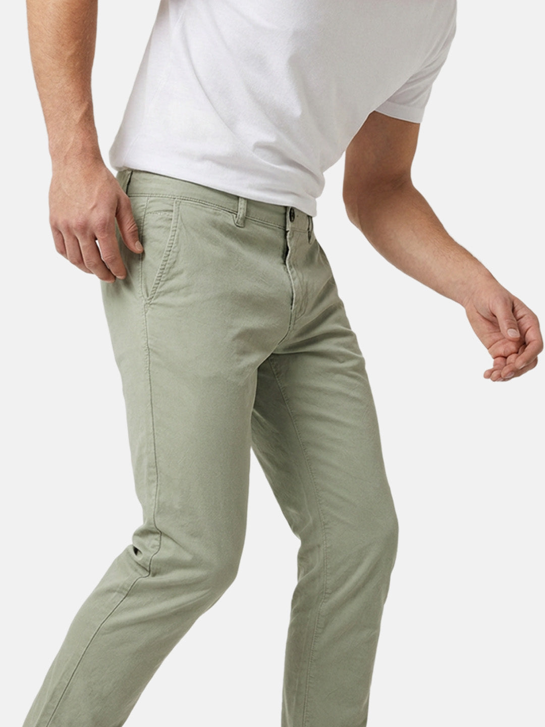 Light green slim-fit men’s chino pants shown in motion, highlighting fit and fabric.