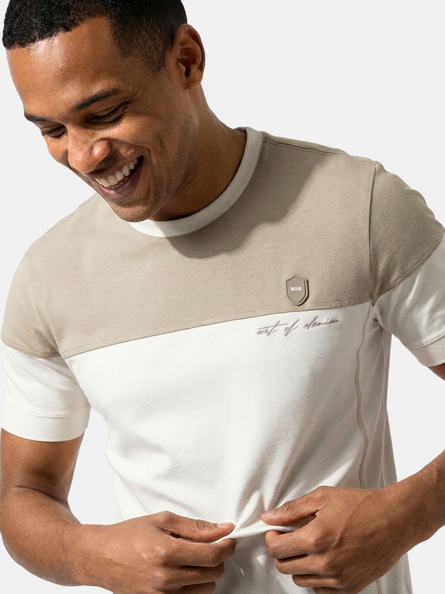 Close-up of off-white men’s T-shirt with beige chest panel and Wam Denim logo