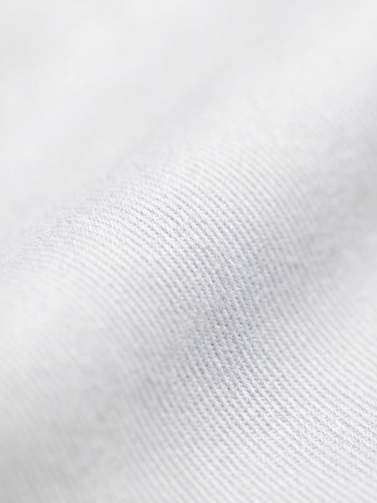 Close-up of white cotton fabric texture from men’s dress shirt