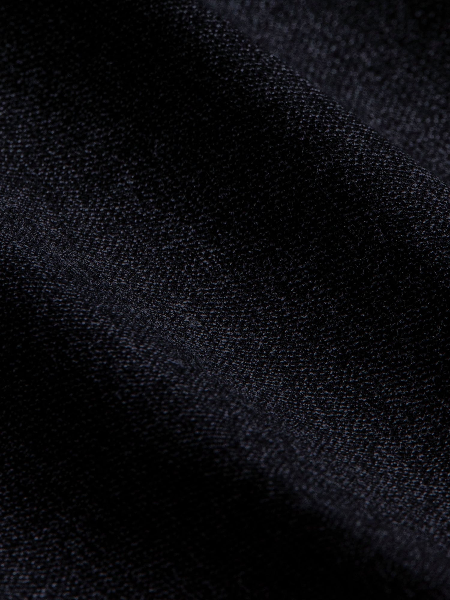 Close-up of dark navy chino fabric highlighting fine weave and premium texture.