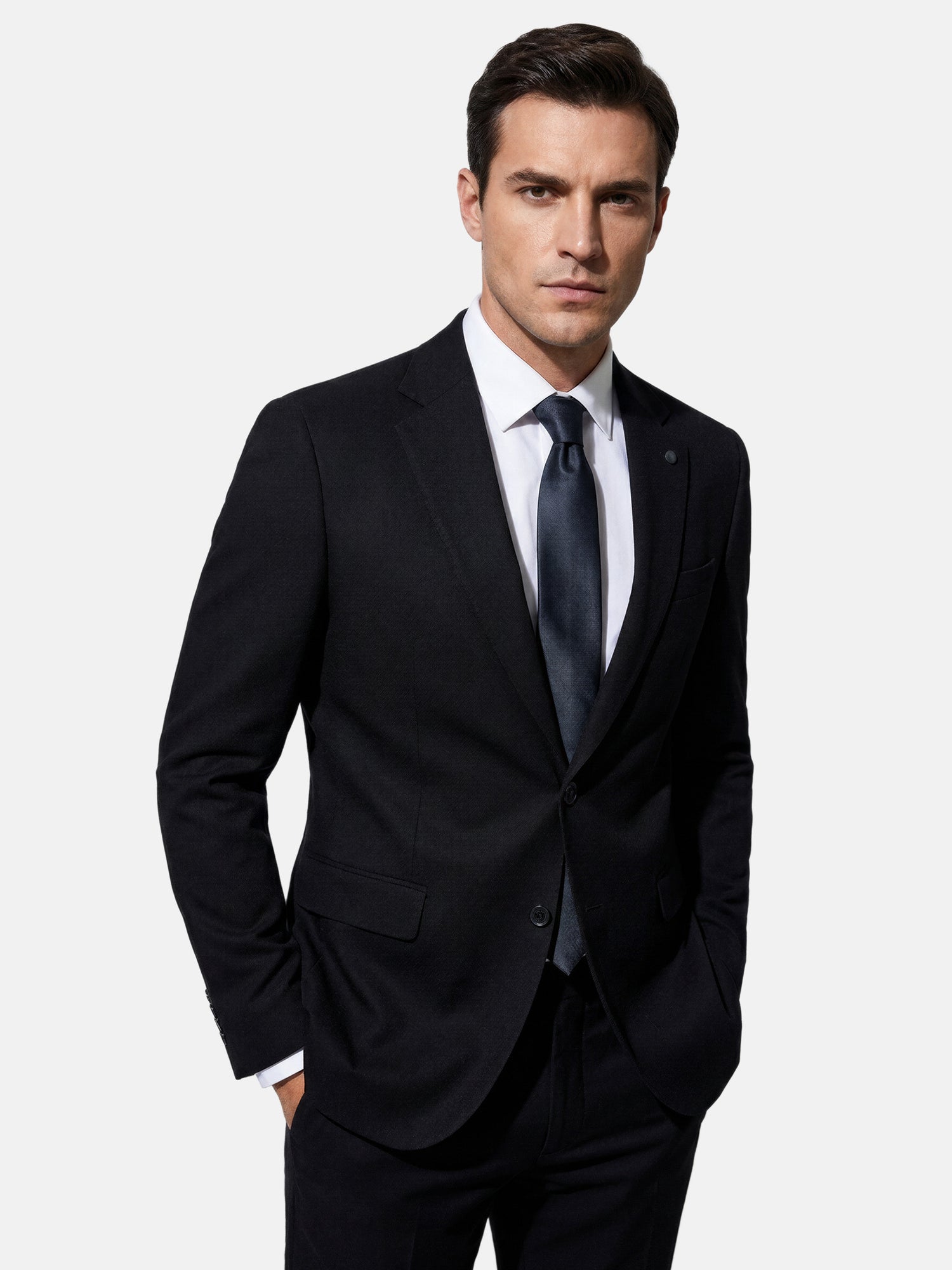 Close-up of model wearing black suit blazer with slim fit and classic notch lapel.