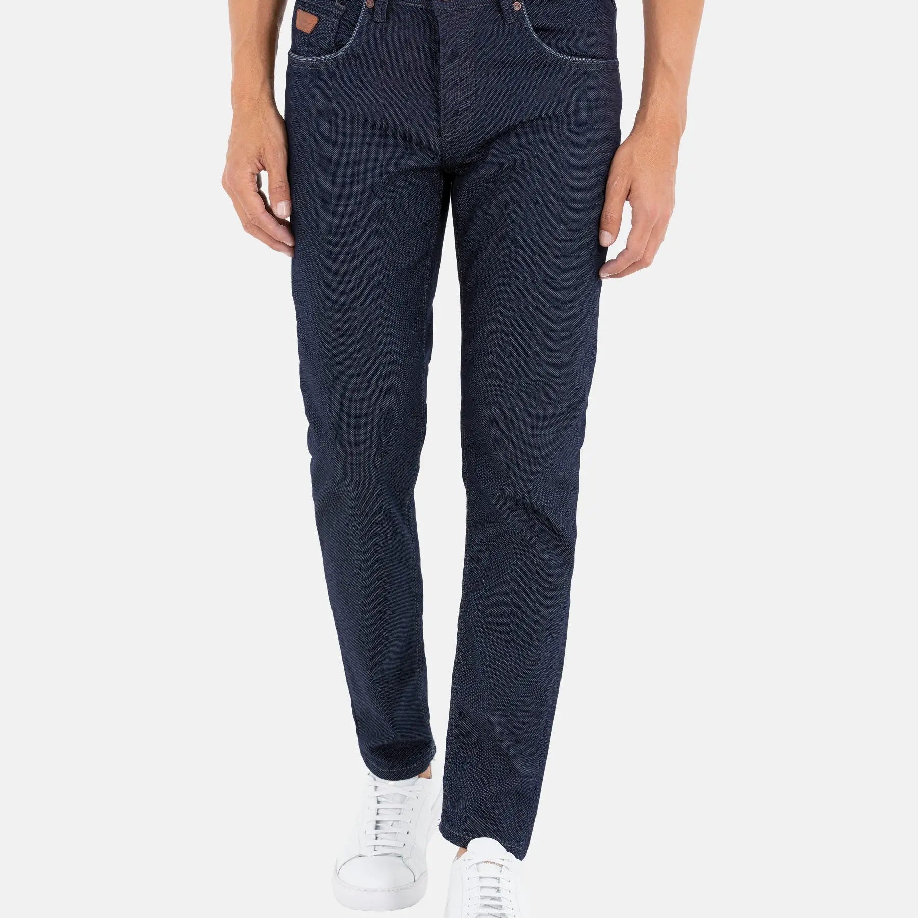 Men’s slim-fit dark blue jeans paired with white sneakers – Wam Denim.