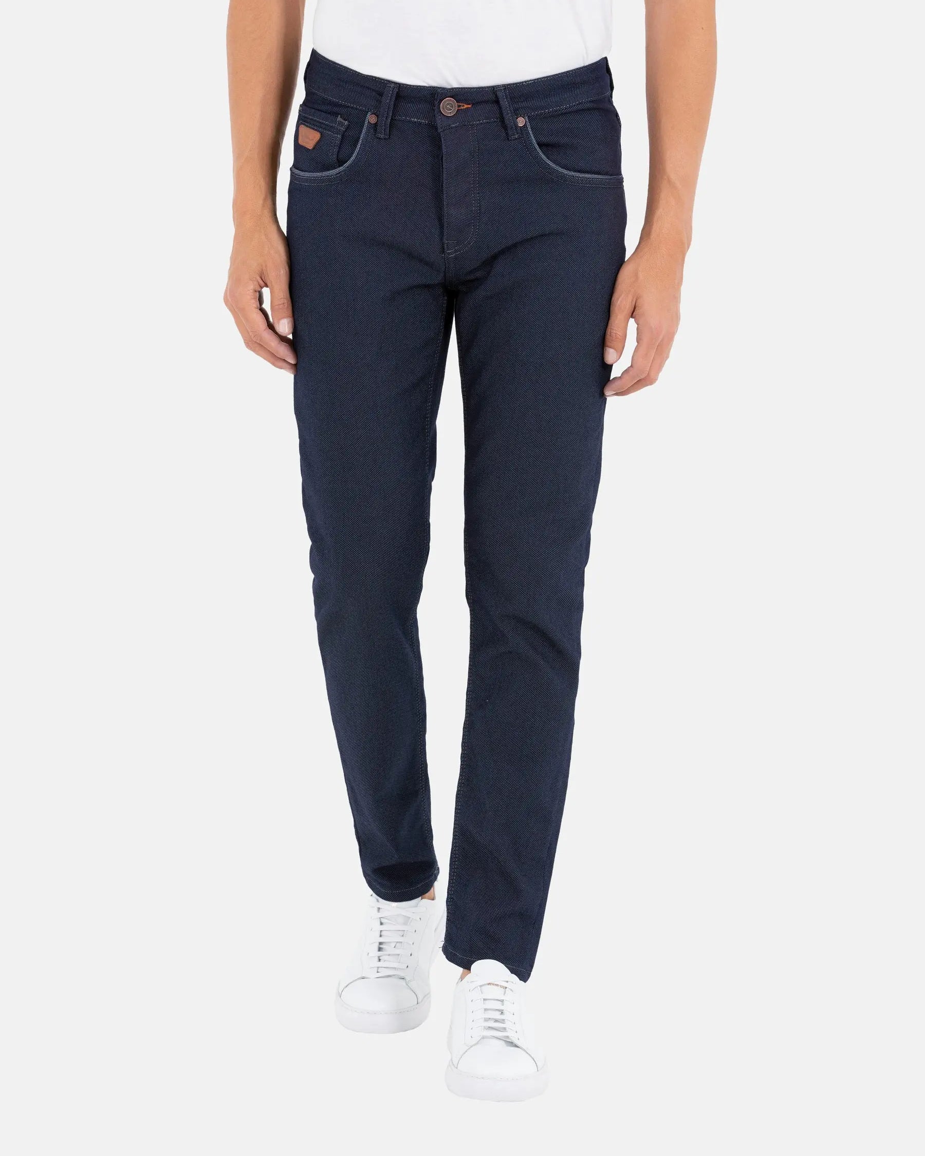 Men’s slim-fit dark blue jeans paired with white sneakers – Wam Denim.