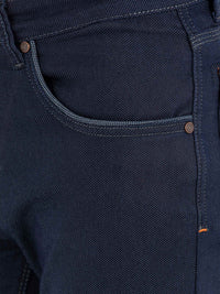 Close-up of front pocket and stitching on dark blue slim-fit jeans – Wam Denim.
