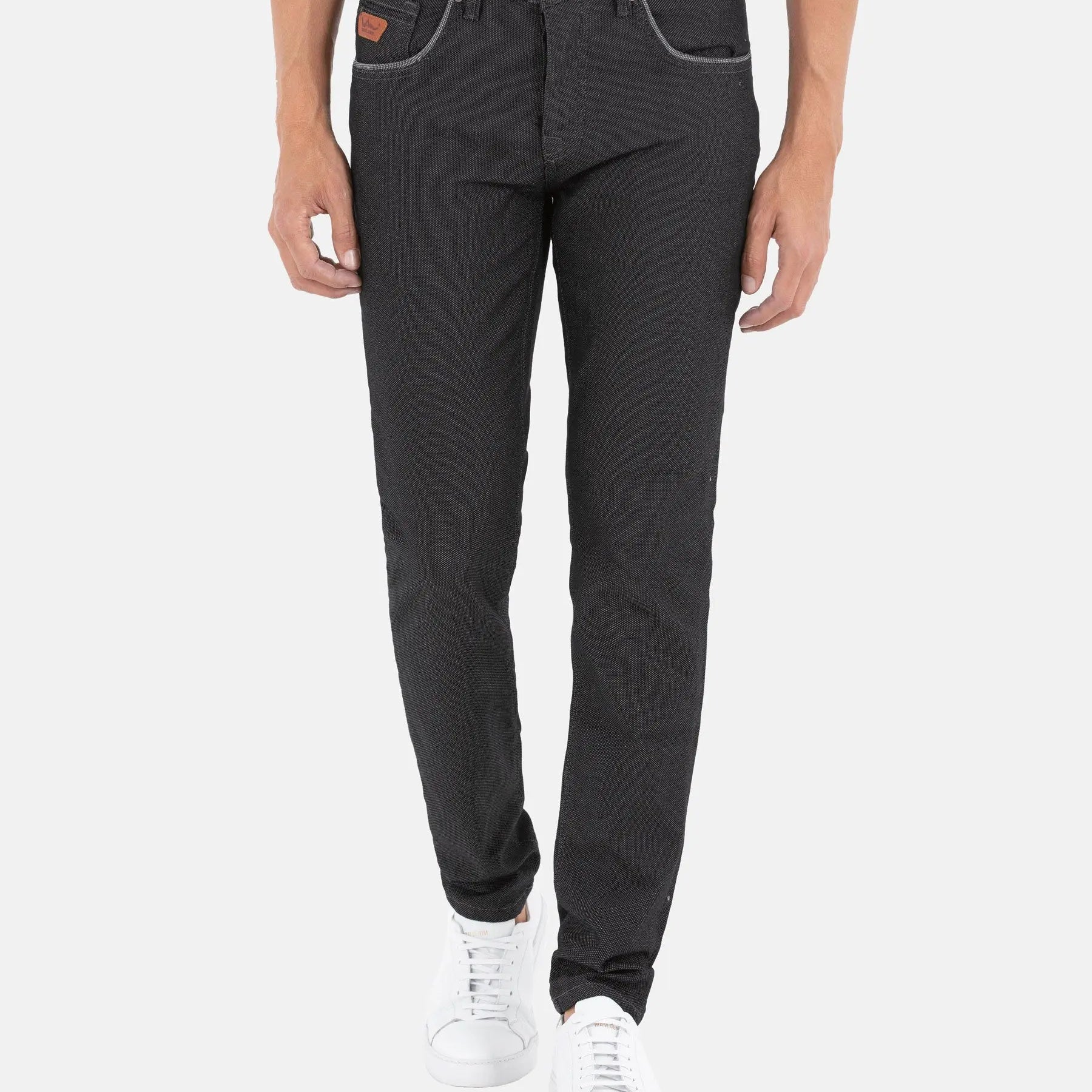 Man wearing slim-fit black patterned jeans with white sneakers and contrast stitching – Wam Denim.