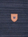 Close-up of a textured blue fabric with a brown leather patch featuring a 'W' logo.