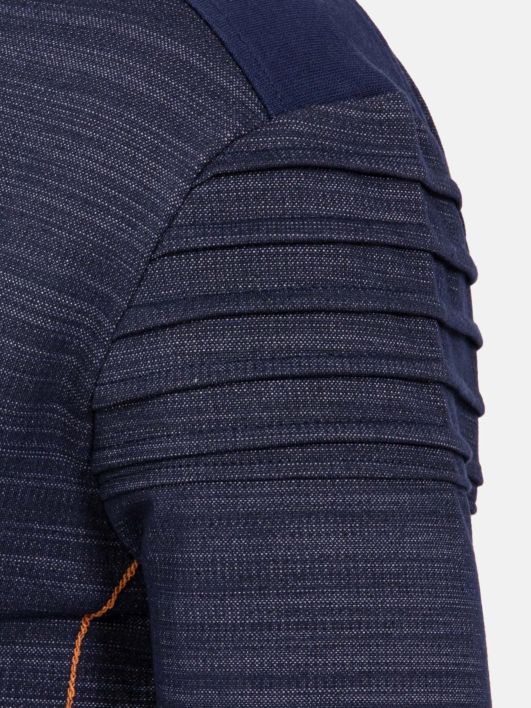 Close-up of a textured navy fabric with pleated detailing on a white background