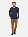 Man wearing a navy striped sweater and brown pants on a white background