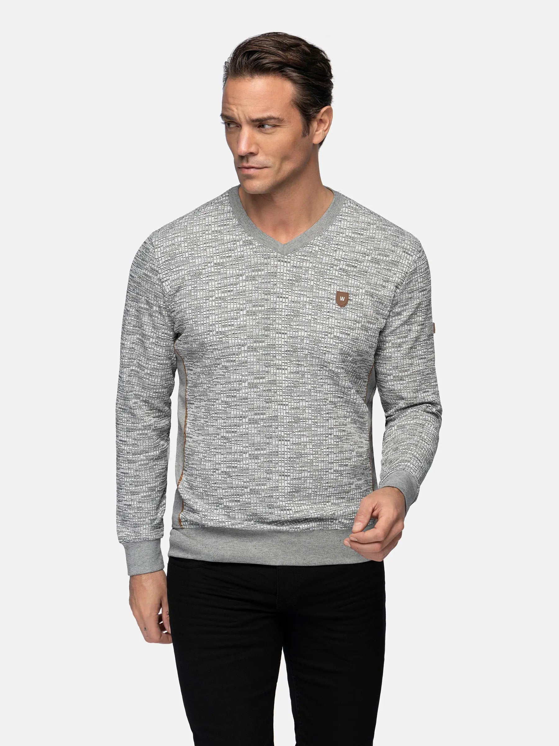 Three-quarter shot of a man wearing a grey V-neck sweater – Wam Denim.