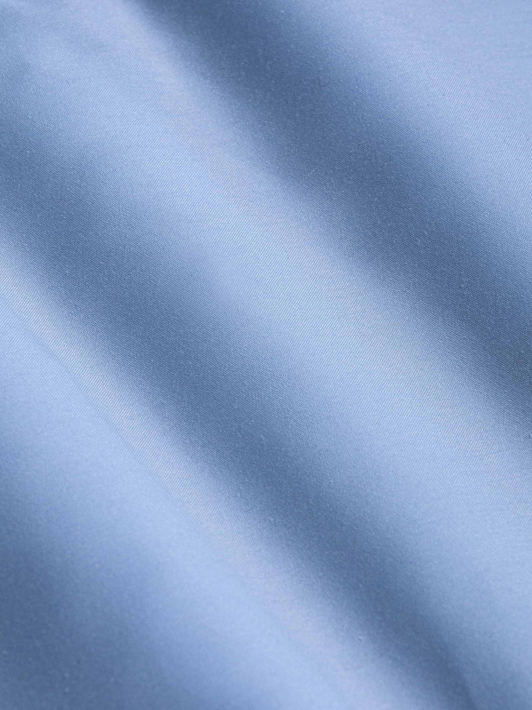 Close-up of smooth light blue fabric showing soft texture and fine weave – Wam Denim.