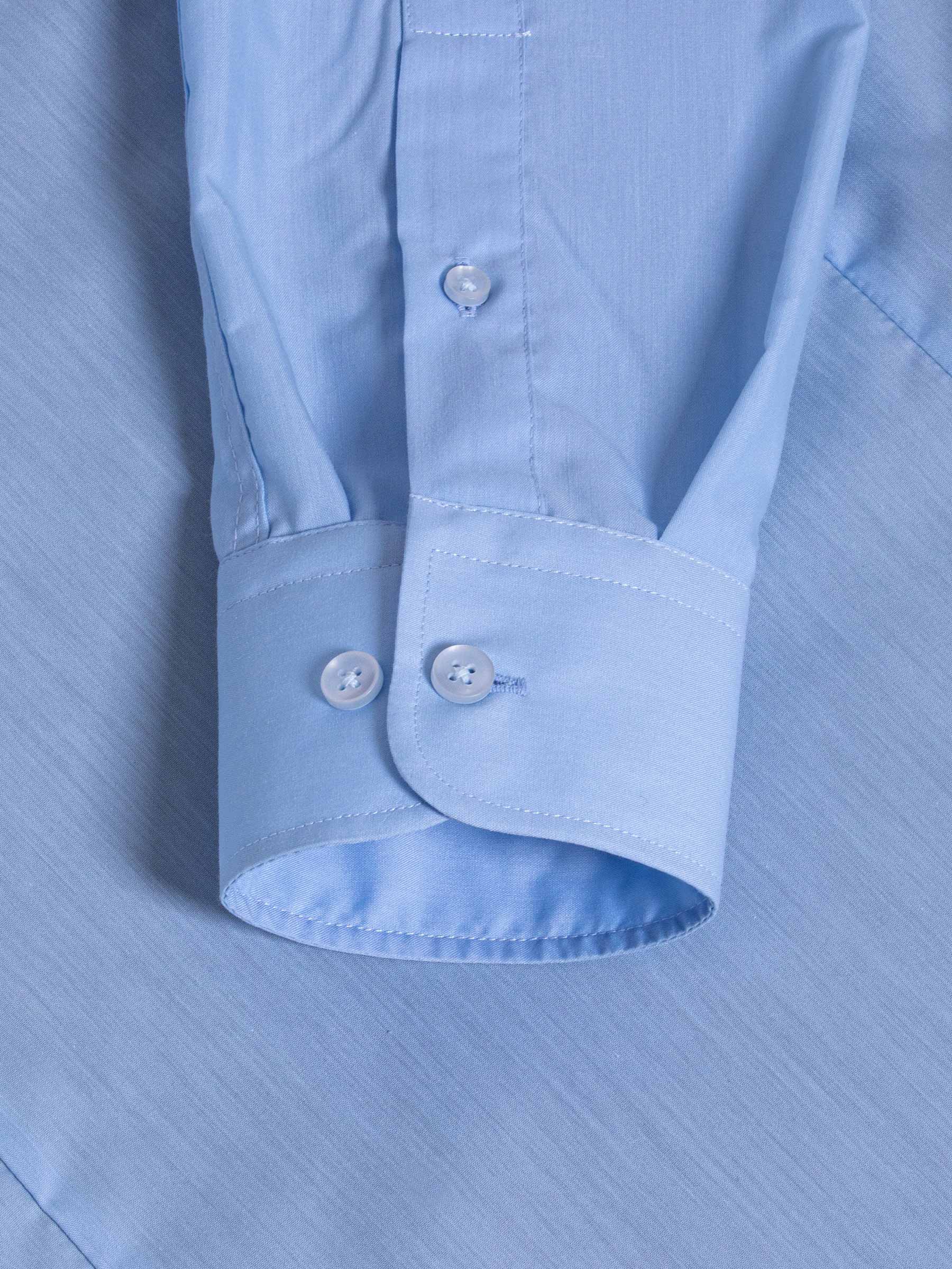 Close-up of light blue dress shirt cuff with double buttons and fine stitching – Wam Denim.